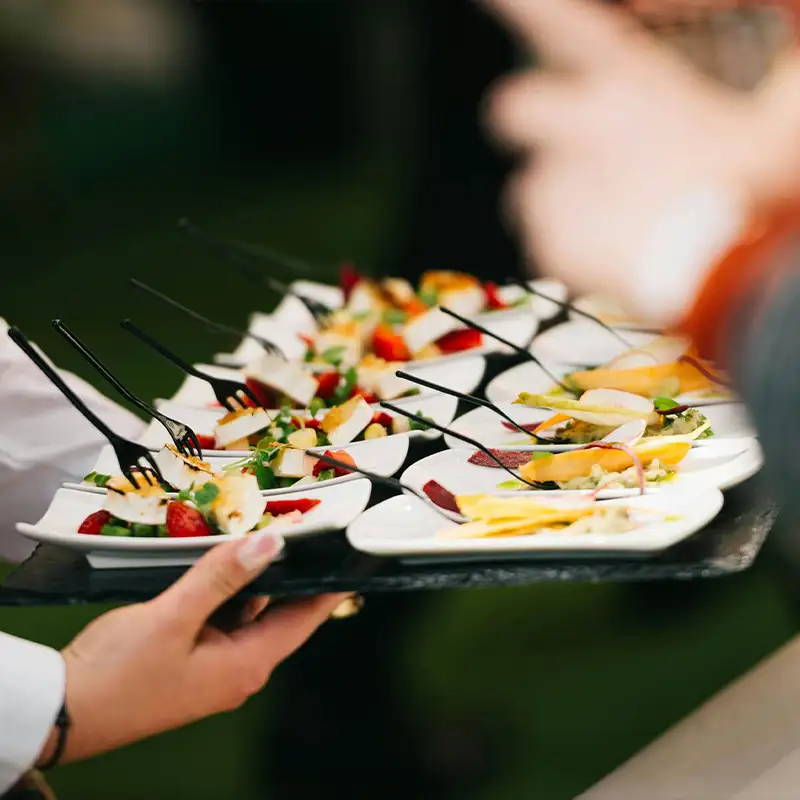 Dessertteller mit Schokoladencreme, Sahne, Erdbeere, Johannisbeeren, Brombeeren und einer rechteckigen Tarte mit Pistazien und Schokostückchen.