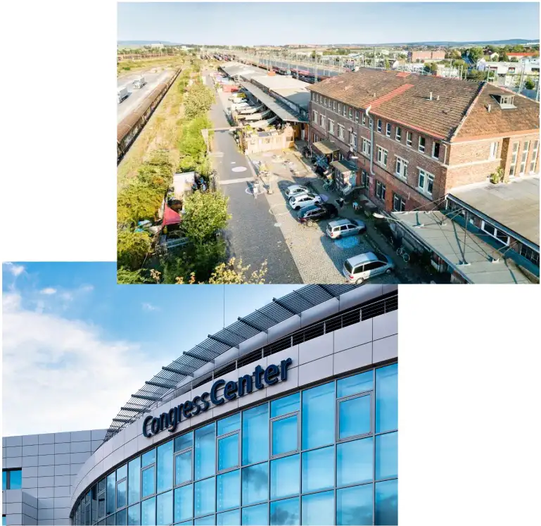 Historisches Bahnhofsgebäude mit Bahnsteigen und Gleisen, darunter moderne Glasfassade eines Kongresszentrums mit Beschriftung